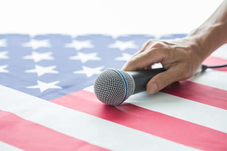 Man hand grabbing microphone on United State of America flag