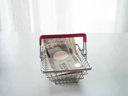 Japanese Yen in basket on white background