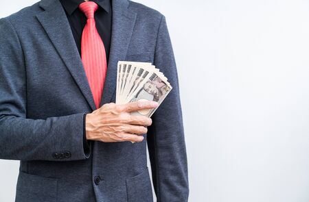 Businessman with ten thousand yen banknote on white backgroundの写真素材