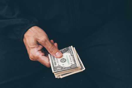 Poor man hand open wallet with one US dollar