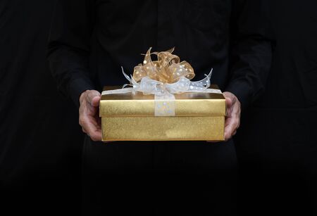 hand holding gold gift boxの写真素材