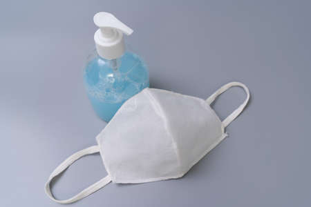 White face mask and alcohol gel for protection COVID-19 pandemic