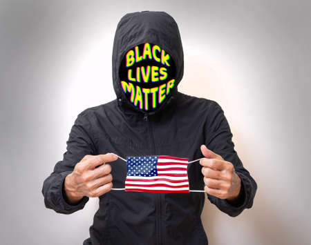 Black lives matter man holding US flag face mask. protester and COVID-19 situation in America