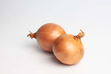 brown onions isolated on white backgroundの写真素材