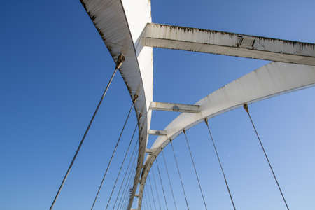 ANTIQUE WHITE STEEL METAL BRIDGE AT LOW TIDE ON A SUNNY SUMMER DAYの写真素材