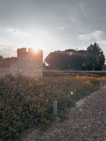 Ancient medieval castle with moat in front at sunset with the sun beating on the tower in Spain.の写真素材