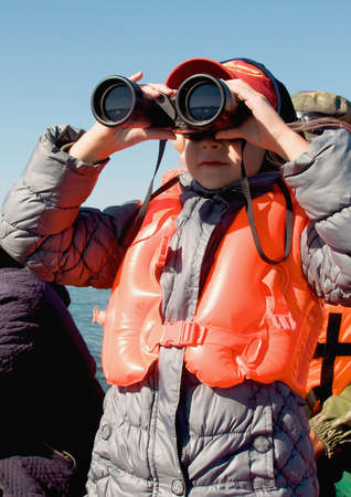 girl looking through binocularsの写真素材