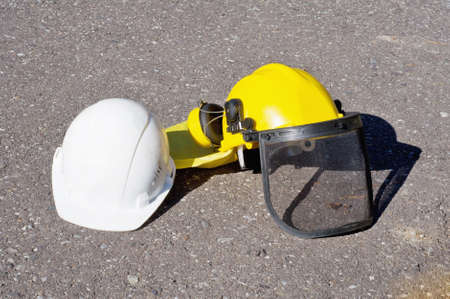 yellow and white construction helmets on the pavementの写真素材