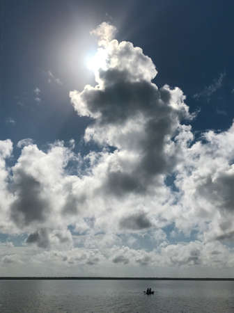 A calm lake surrounded by incredible clouds.