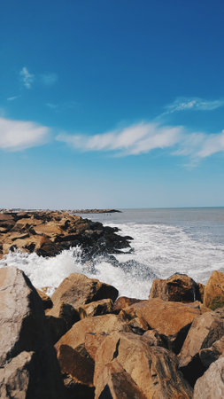 Breakwater, beach, rocks sky with clouds seaの写真素材