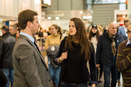 Man and woman walking in the crowd attending an event at the convention trade center in Brno. BVV Brno Exhibition center. Czech Republicのeditorial素材