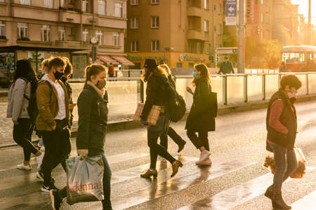 Man is walking alone in Prague 7 district carrying her shopping bags during quarantine period due to outbreak of COVID-19 as winter is starting, Czech Republicのeditorial素材