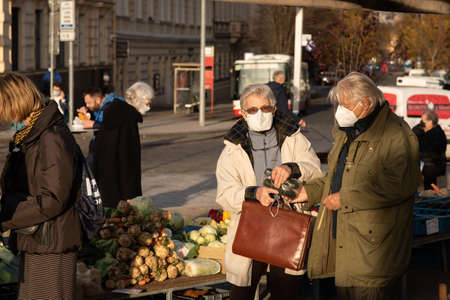 11-23-2020. Prague, Czech Republic. People walking and talking outside during coronavirus (COVID-19) at Hradcanska metro stop in Prague 6. Man getting out the tram.のeditorial素材