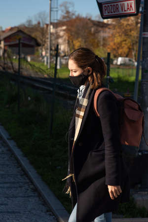 11-22-2020. Prague, Czech Republic. People during quarantine period due to coronavirus (COVID-19) at Hradcanska metro stop in Prague 6. Young woman walking.のeditorial素材