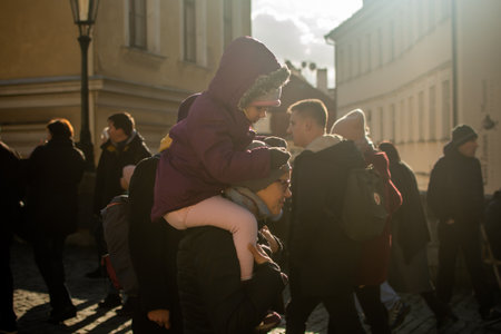 Prague, Czech Republic. 01-11-2020. Tourists are walking on the Charles Bridge on the Historical town in Prague. Mother carrying her daughter in her shoulders at the Charles Bridge in Prague..のeditorial素材