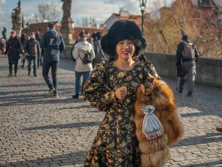 Prague, Czech Republic. 01-11-2020. Tourists are walking on the Charles Bridge on the Historical town in Prague. An asian woman tourist is posing for a photo at the Charles Bridge in Prague.のeditorial素材