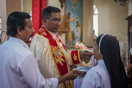 Kerala, India, 08-12-2017. Priest giving body of christ to nun. Catholic wedding in the Province of...