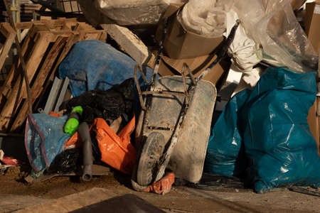 Rubbish from demolition. Wheelbarrow and rubbish. Construction site. Building is being...