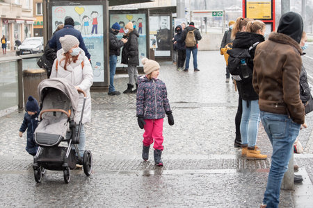 Prague, Czech Republic. 01-07-2021. People walking on the platform after descending from the tram at Hradcanska station in Prague 6 while snowing.のeditorial素材