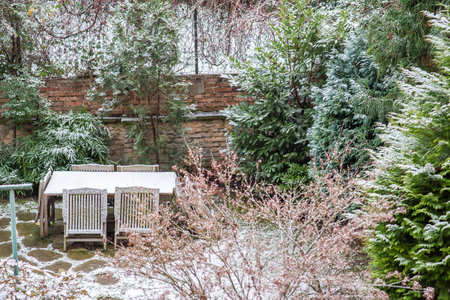 Prague, Czech Republic. 01-08-2021. Garden with table and tree on a snowing day, close to Hradcanska metro station on Prague 6のeditorial素材