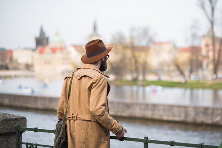 Prague, Czech Republic. 09-23-2019. Man giving the back to the camera watching the Vltava river while walking and enjoying close to the Charles Bridge during a sunny day in Prague.のeditorial素材