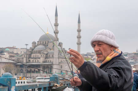 Istanbul, Turkey. 05-23-2018. Muslim fisherman with a mosque at the background facing the ocean of Istanbul in Turkey.のeditorial素材