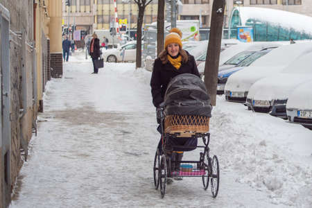 Prague, Czech Republic. 02-08-2021. Mother with pram smiling walking in the city center of Prague on...