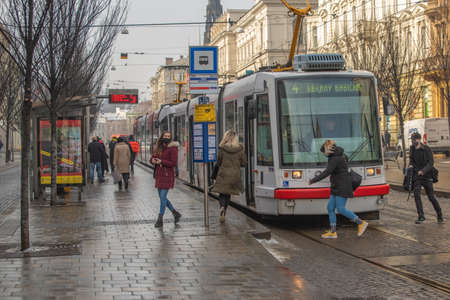 Brno, Czech Republic. 02-17-2021. People with face mask to protect from corona virus walk on Cheska tram stop in the city of Brno on cold winter day.のeditorial素材