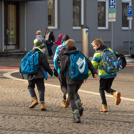 Brno, Czech Republic. 02-17-2021. Children out of school are running on Cheska tram stop in the city...