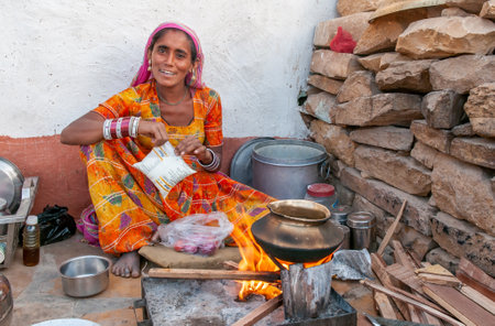 Rajasthan. India. 07-02-2018.Women cooking for children in rural community. Women apart of taking care of children, they have an important role financial provider of their families.のeditorial素材