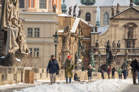 Prague, Czech Republic. 02-23-2021. Tourists in the city center of Prague walking and talking on the Charles Bridge, enjoying a cold day during winterのeditorial素材