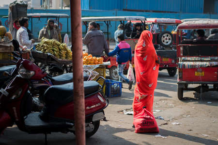 Jaipur, India. 09-05-2018. Indian woman walking on the streets of Jaipur in the Rajasthan while buying fruits and vegetables in the local market.のeditorial素材