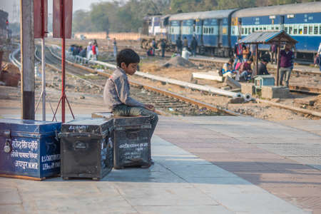 Jaipur, India. 09-05-2018. A lonely boy is sitting with his belonging at the main train station in Jaipur.のeditorial素材