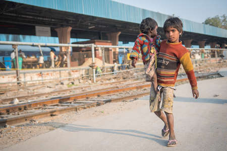 Jaipur, India. 09-05-2018. A child is carrying his small sister at the main train station in Jaipur.のeditorial素材