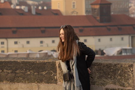 Prague, Czech Republic. 03-02-2021. Beautiful woman on the Charles Bridge in the city center of Prague during winter with a beautiful sunset.のeditorial素材