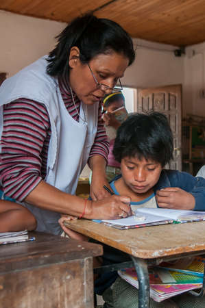 Chaco Province. Argentine. 15-01-2019. Indigenous teacher helping students with homework at school in the Chaco Province, North of Argentine.のeditorial素材