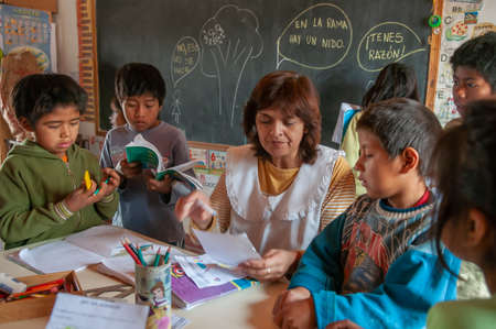 Chaco Province. Argentine. 15-01-2019. Indigenous teacher helping students with homework at school in the Chaco Province, North of Argentine.のeditorial素材