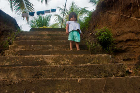 Darien Province, Panama. 07-18-2019. Portrait of and indigenous small girl from the Darien Province, in Panama, Central America standing on the stairs.のeditorial素材