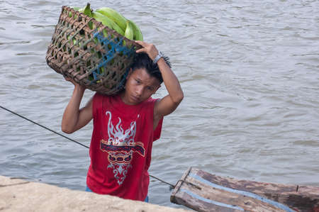 Darien Province, Panama. 07-18-2019. Indigenous young adolescent working on the port of Yaviza carrying vegetables in the Darien Province, Panama, Central America,のeditorial素材