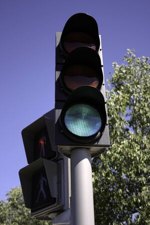 Green traffic light for the cars and red for pedestriansの写真素材