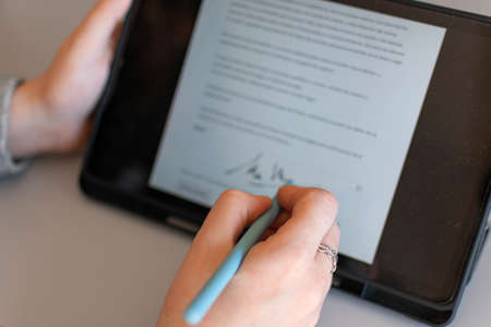 Female GP making electronic notes in tablet pcの写真素材