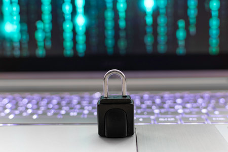 Padlock on the laptop keyboard with binary code in the background.の写真素材