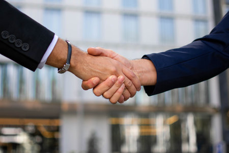 Close-up of business people shaking hands on the background of buildingの写真素材