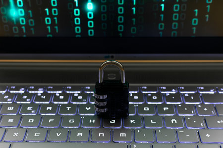 Padlock on the keyboard of a laptop with binary code in the backgroundの写真素材