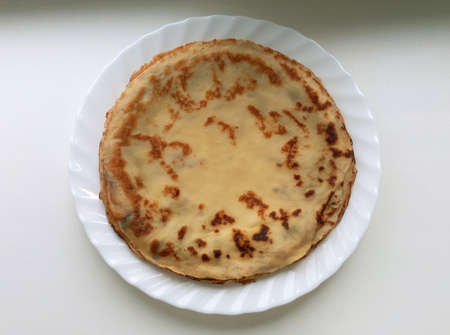 Pancakes in a plate on a white background, baked ruddy,view from above, useful and nutritious food