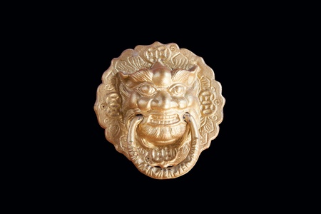 Golden lion head knocker isolated on the black background