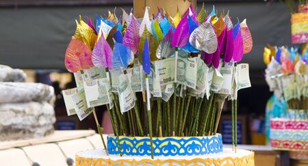 Money for making merit attached with colorful Bothi leavesの写真素材
