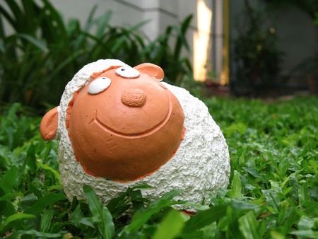 White sheep pottery in the green yardの写真素材