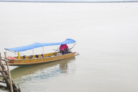 A man checking the motor of the boat before leaving sea hutの写真素材