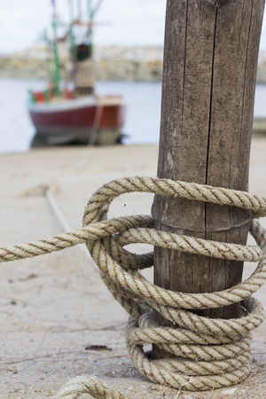 The rope tying boat with a wooden postの写真素材